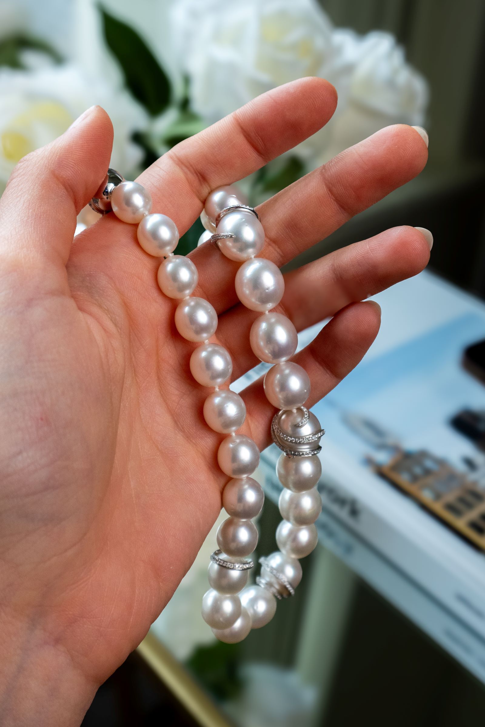 Woman's hand holding cream colored South SEa pearls. Woman's hand holding cream colored South SEa pearls.